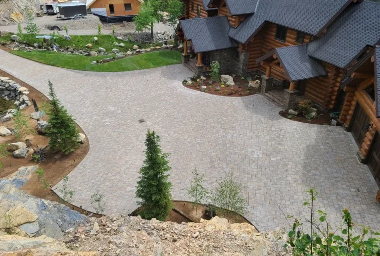 Landscaped driveway entrance by Outdoors by Design